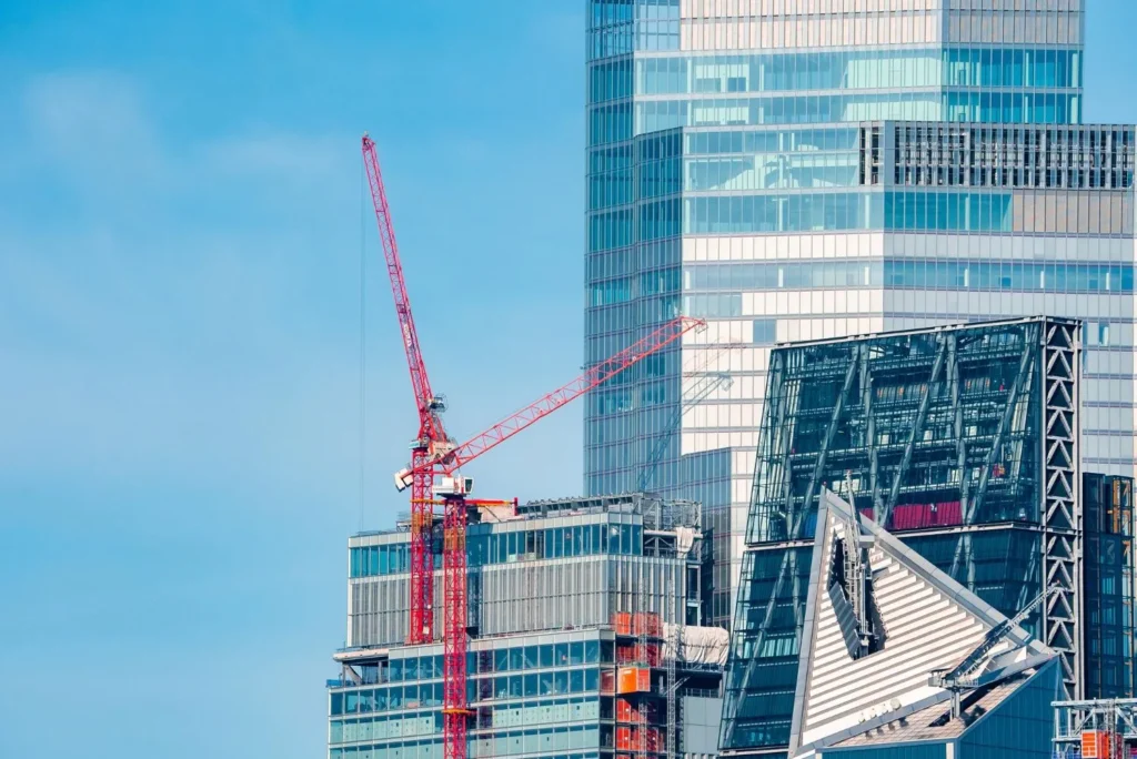 Urban construction site with cranes and high rise buildings under development.