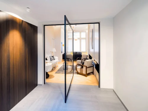 Un appartement contemporain doté d'une porte pivotante coulissante et de boiseries élégantes dans toute la décoration intérieure