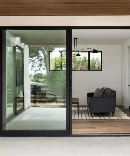 Une maison contemporaine dotée d'élégantes portes coulissantes en verre qui améliorent la lumière naturelle et l'accès extérieur