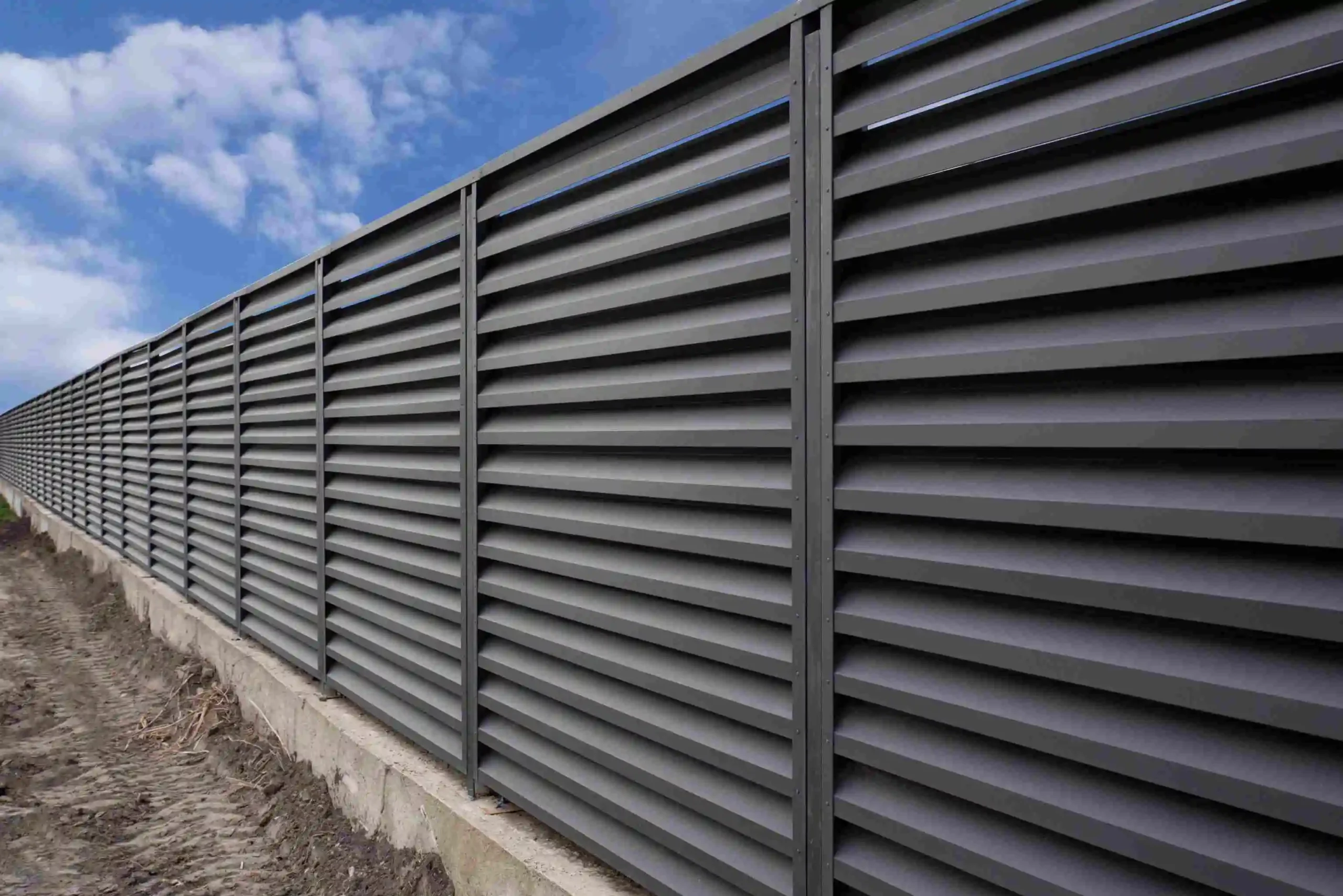 A sleek facade louver featuring a fence constructed from metal slats showcasing modern architectural design elements