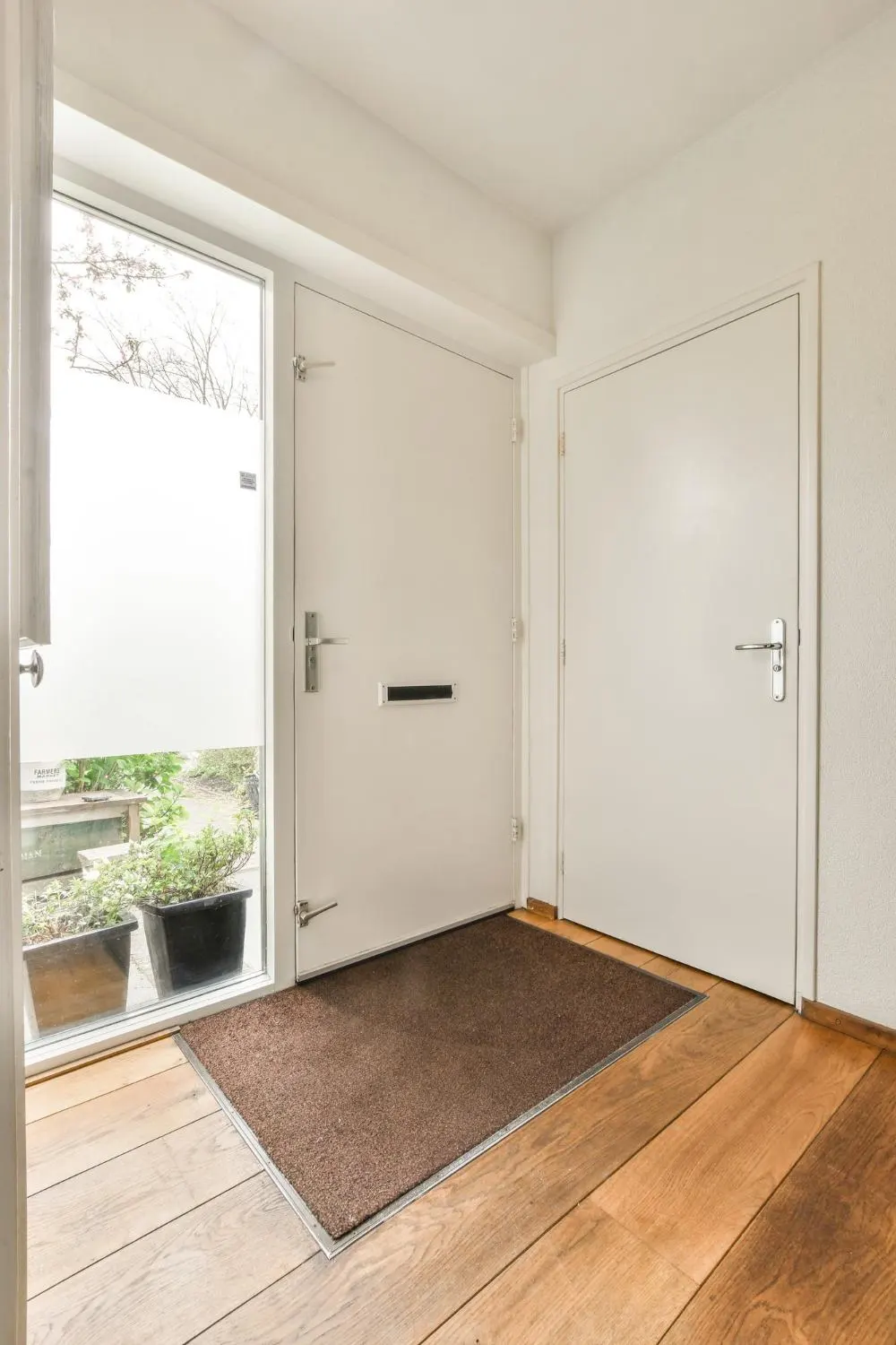 An empty hallway featuring a hinged door and polished wooden floor creating a serene and inviting atmosphere