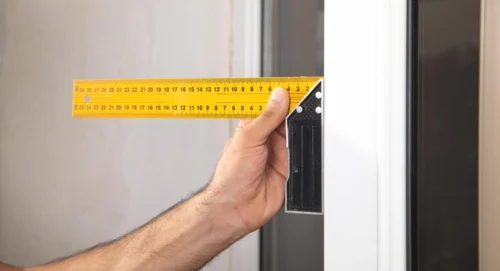 1 A man measures a doorway with a tape measure ensuring accurate dimensions for installation or ren