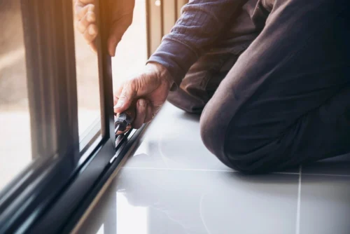 5 A man uses a screwdriver to repair a window demonstrating skill and focus in his task