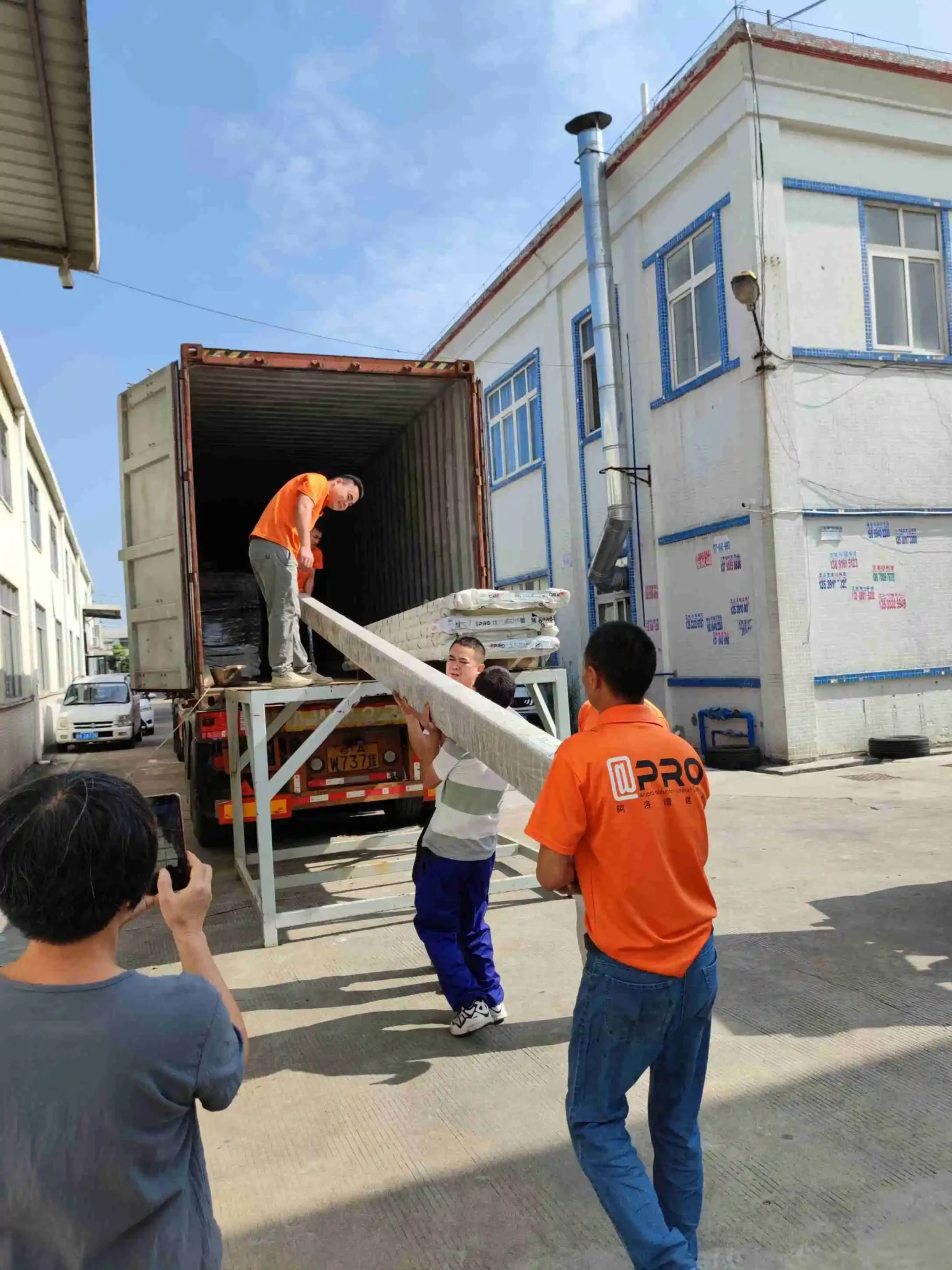 Team loading materials into a shipping container for delivery