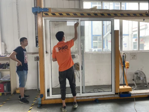 Technician performing final adjustments on a sliding door system at Apro