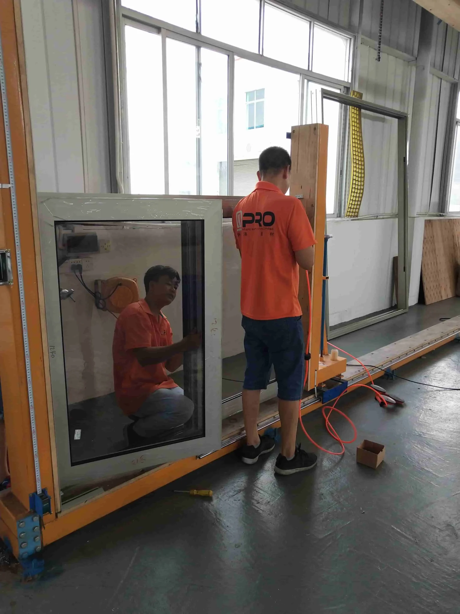 Technicians testing window installation and functionality at Apro facility