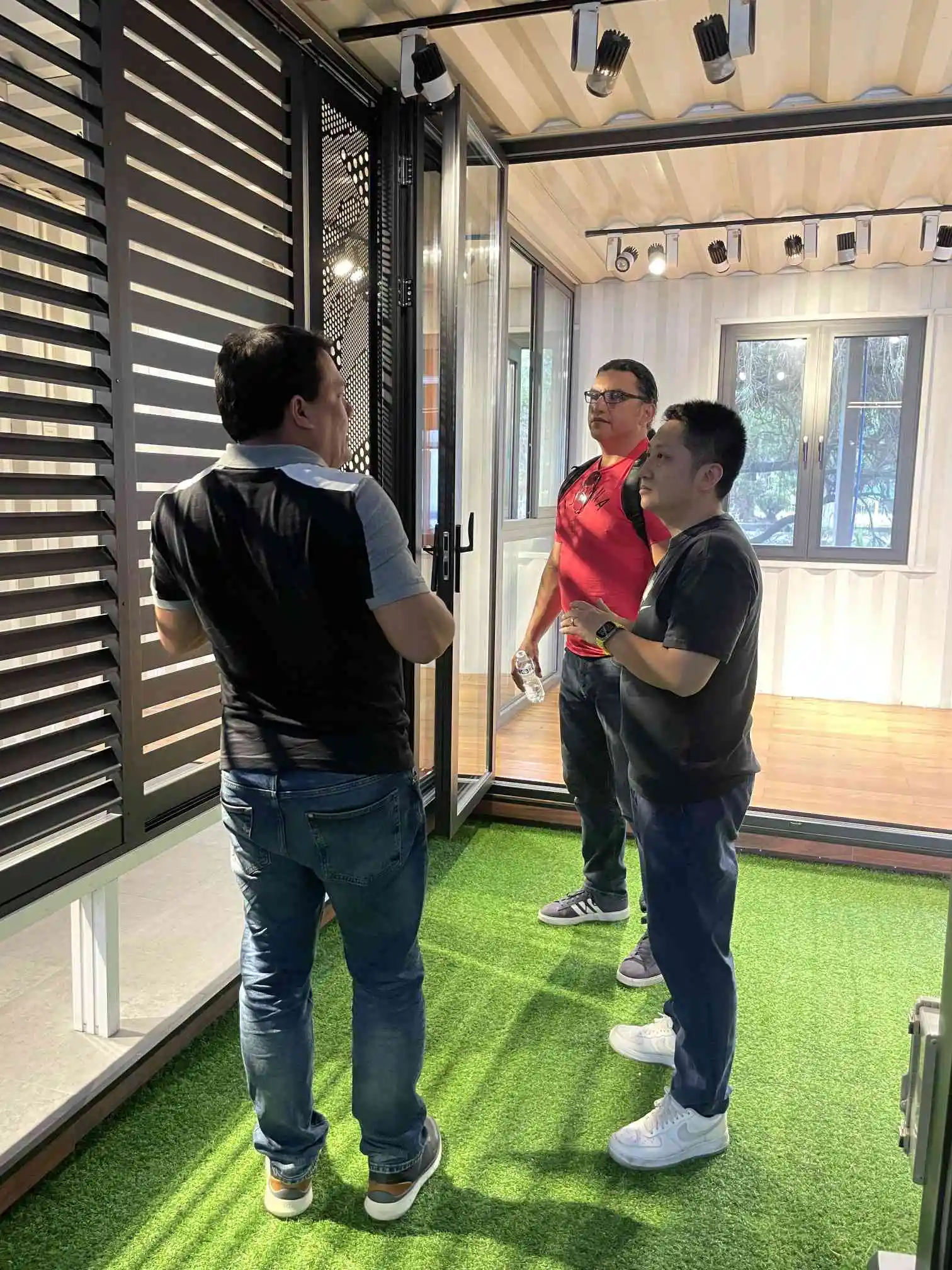 Three people discussing window design during a customer visit inside a showroom