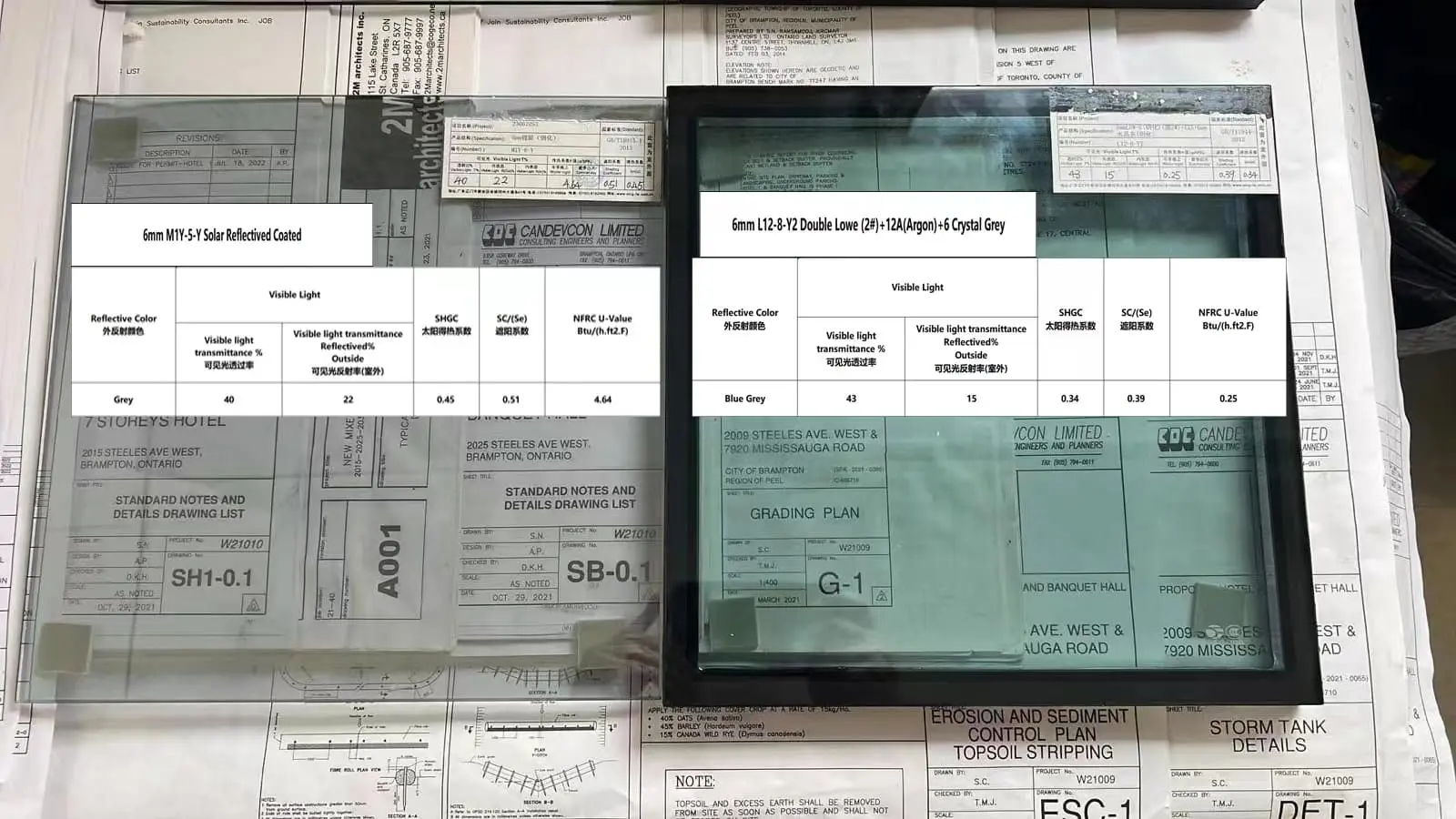 Two glass samples displayed on architectural blueprints labeled with specifications