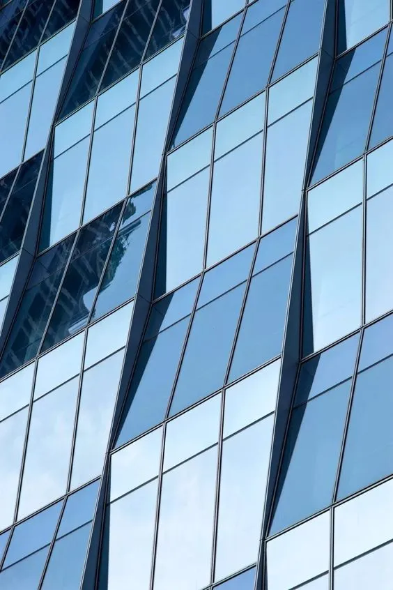 A modern building featuring numerous windows against a clear blue sky illustrating the concept of an invisible curtain wall