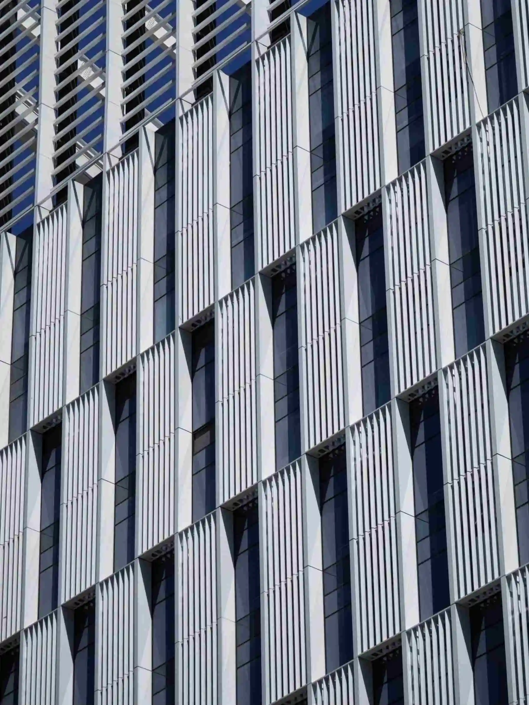 A modern building featuring sleek metal panels showcasing a facade louver installation process