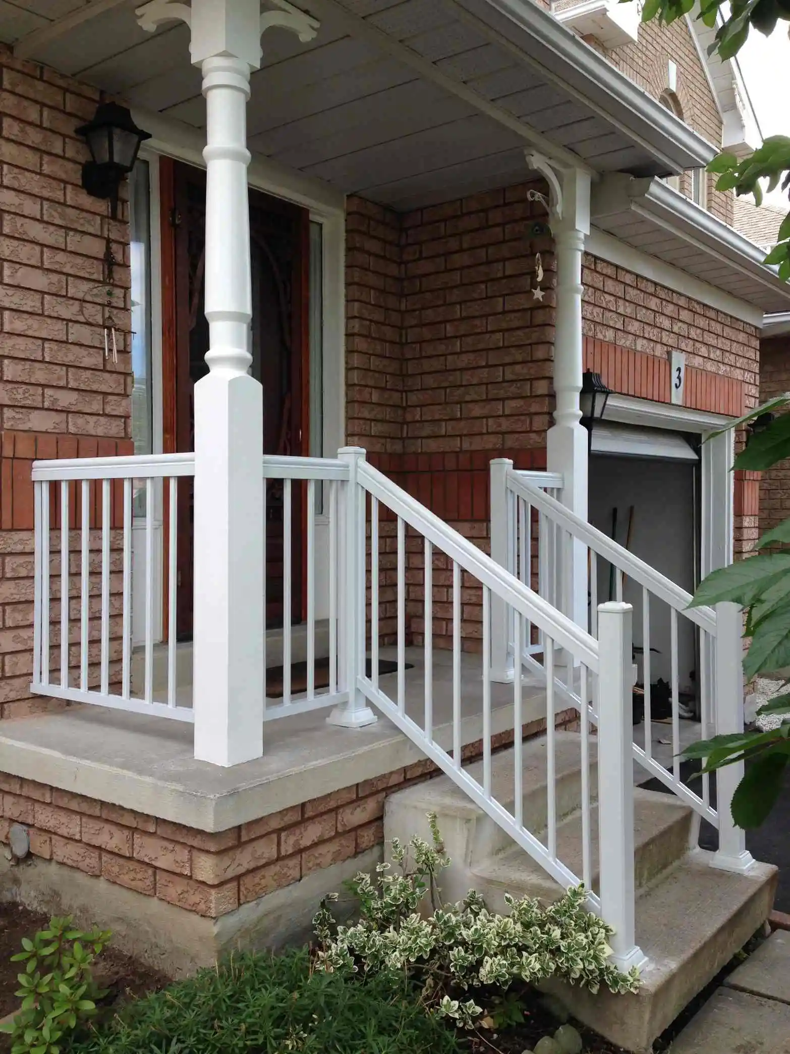 A porch featuring white aluminum railings and a white door creating a clean and inviting entrance