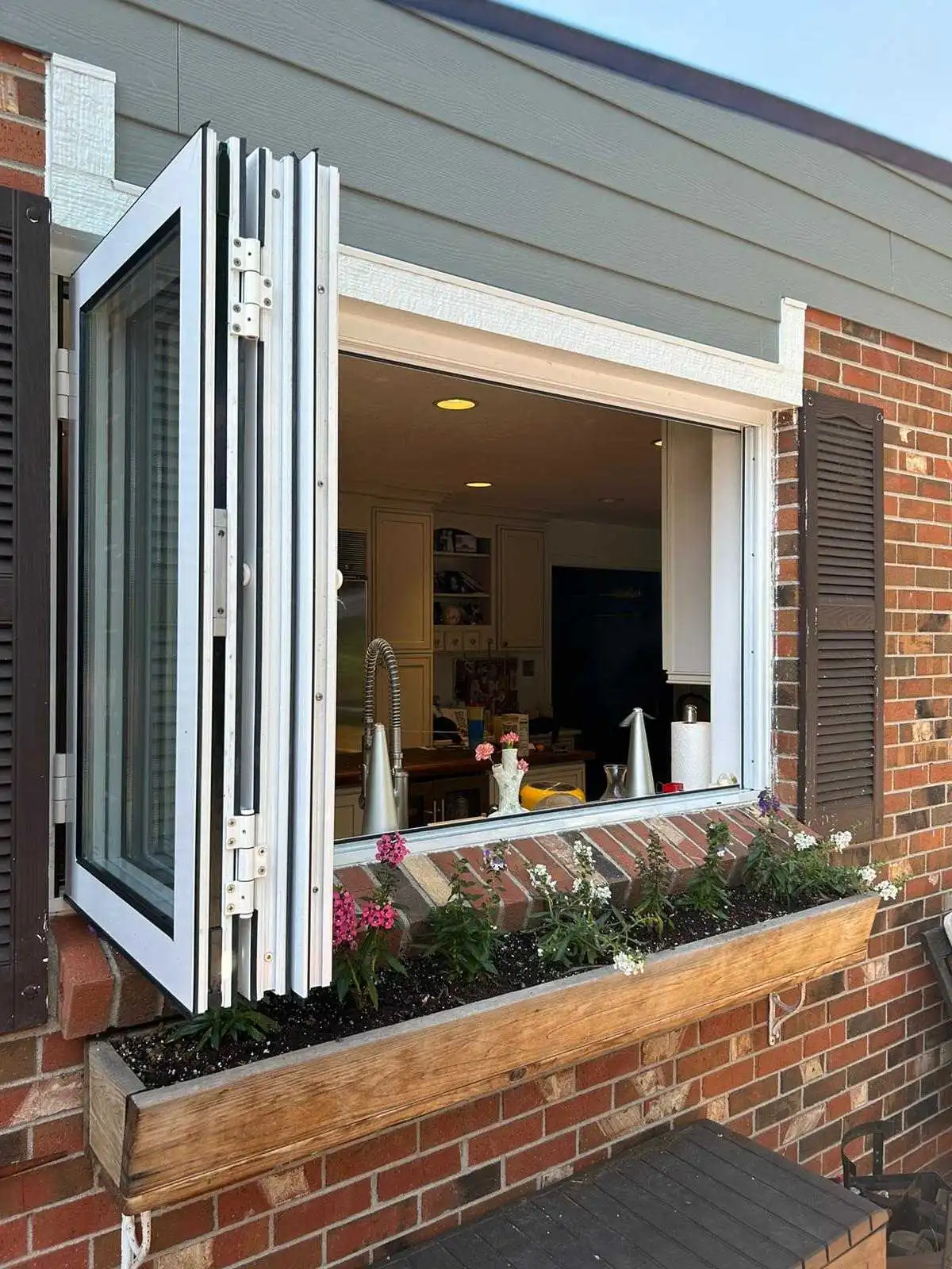 A window featuring a decorative planter showcasing a stylish bi fold window installation