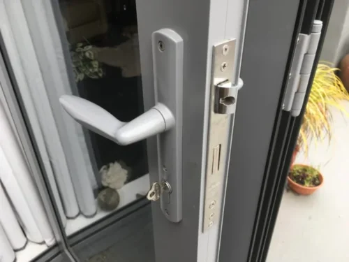 Aluminum sliding door with a locking handle being repaired