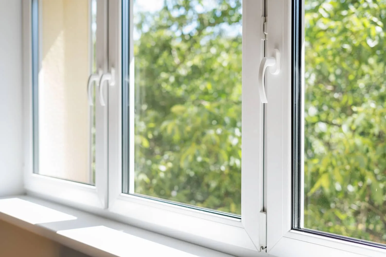 Close up of bright aluminum window frame with green view outside