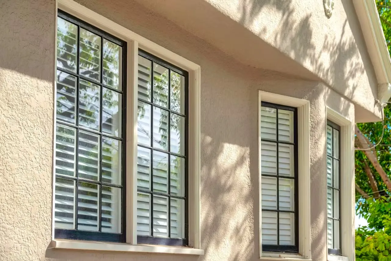 Exterior wall with black aluminum window frames and shutters