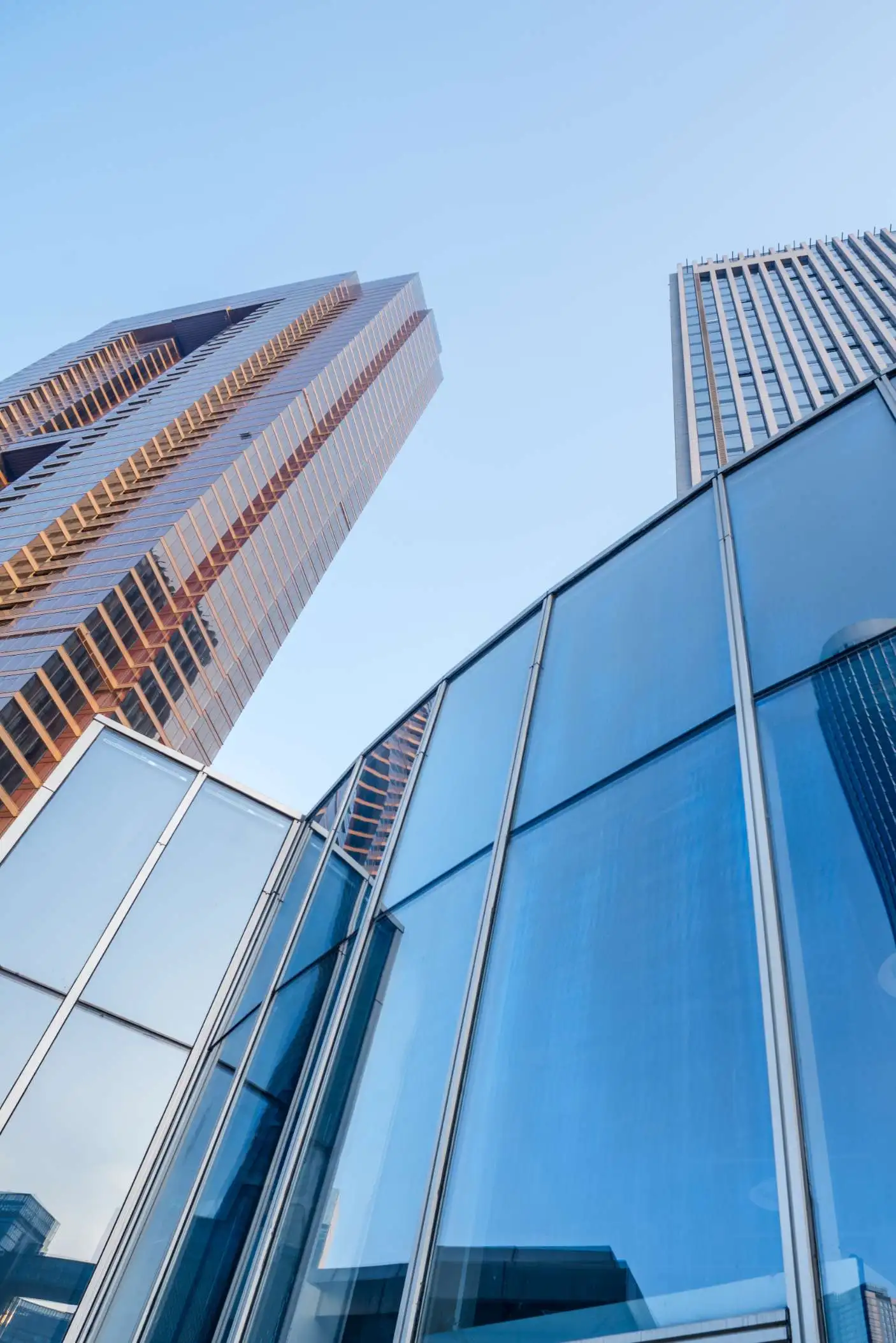 Modern skyscrapers in Los Angeles California featuring a prominent curtain wall design against a clear blue sky