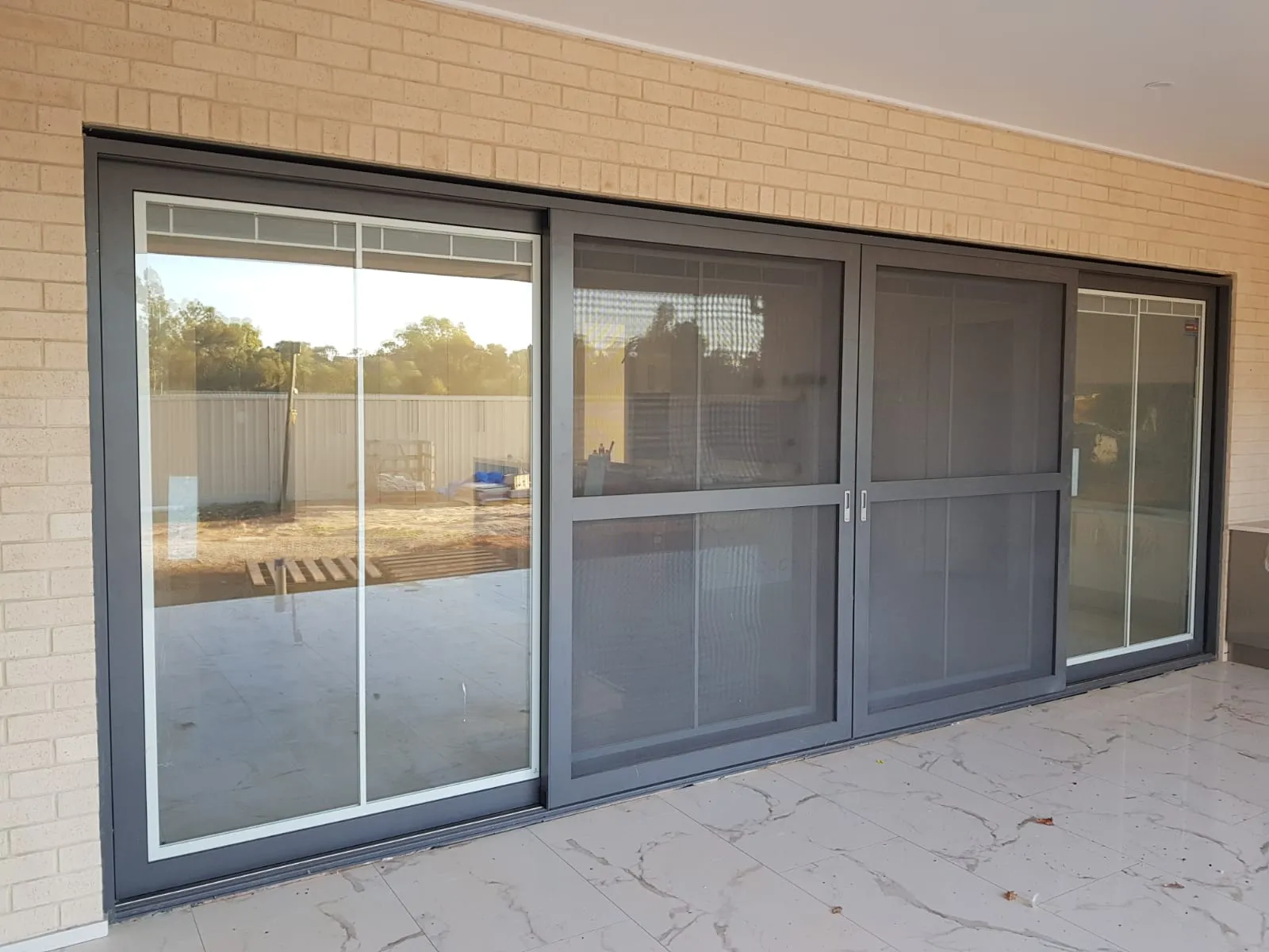 Spacious patio with large sliding glass doors and a tiled floor