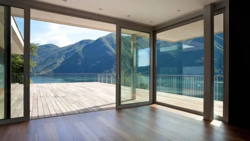 Chambre spacieuse avec portes coulissantes en verre ouvrant sur une vue sur le lac