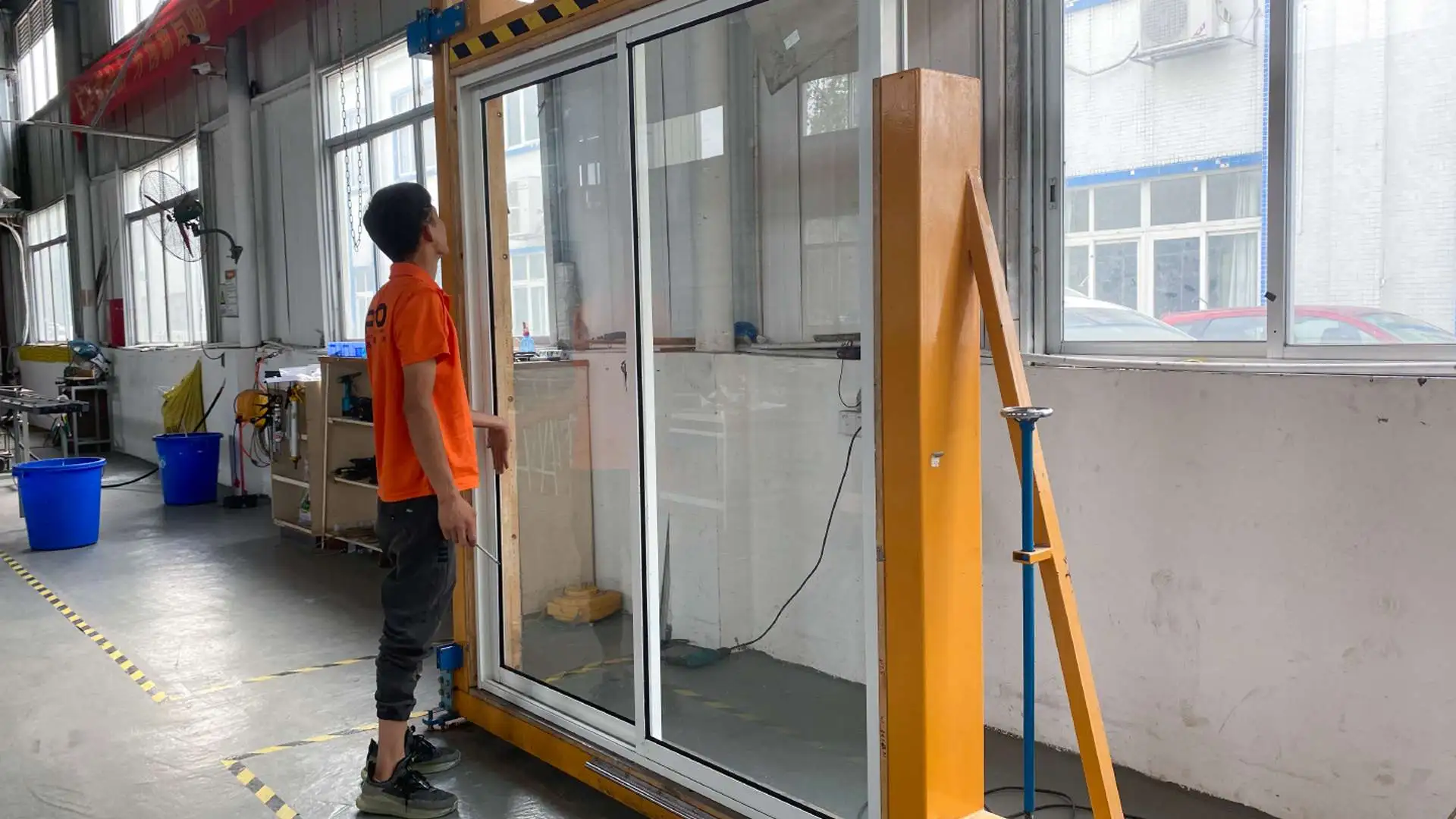 Worker inspecting a glass door installation frame