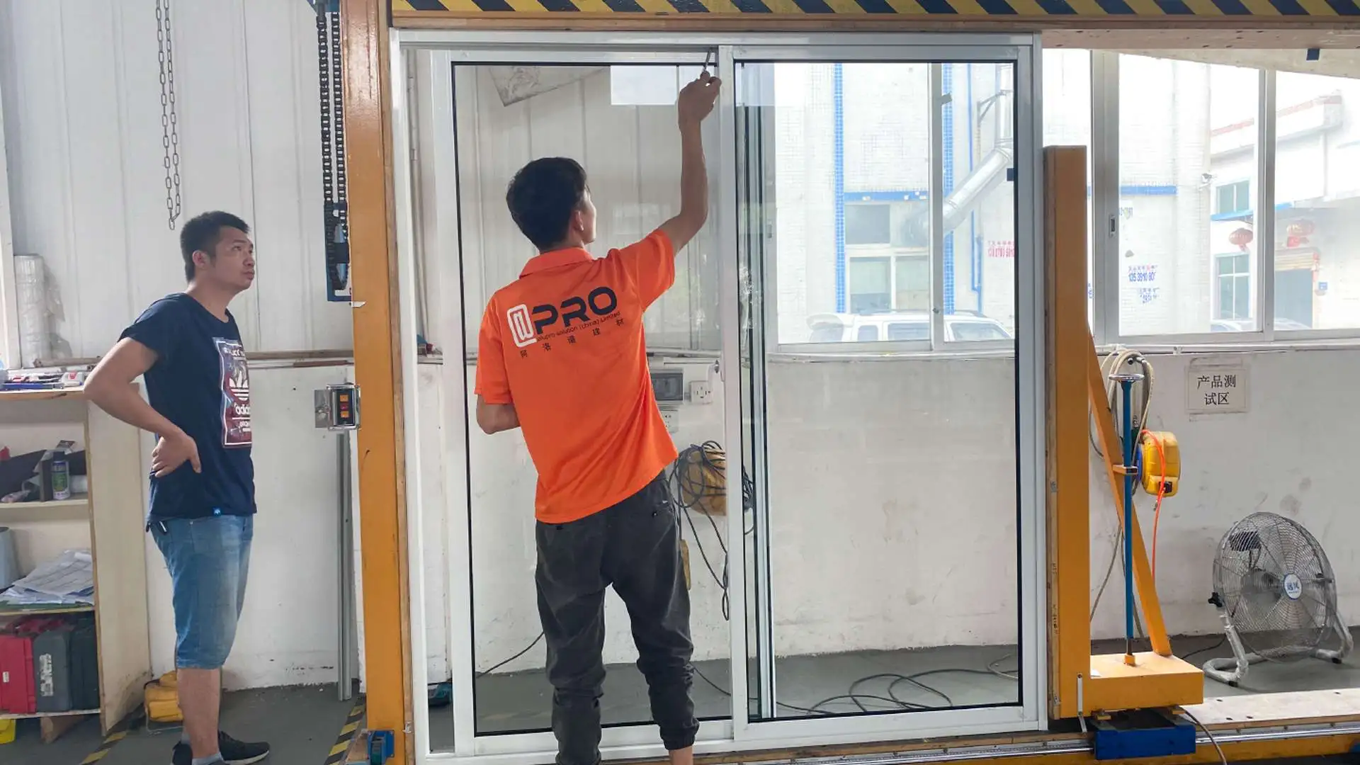 Worker testing a sliding glass doors locking mechanism