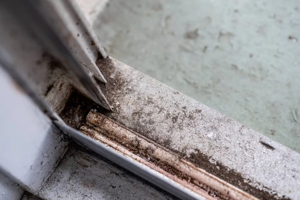 close up of a dirty damaged aluminum window frame needing repair