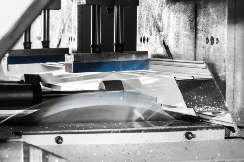 A cutting machine shaping aluminium profiles for door manufacturing