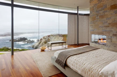 Contemporary Design bedroom with stunning oceanfront view and fireplace