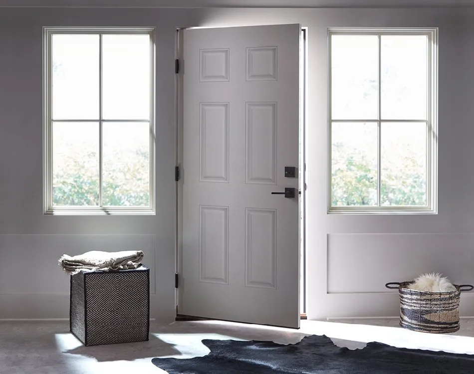 Minimalist white front door with natural light from side windows