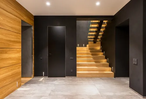 Modern staircase with dark walls and a concealed door