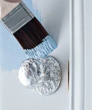 Brush painting a door with foil protecting the door knob