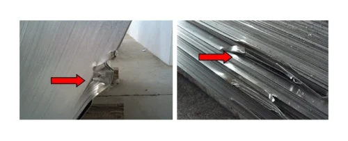 Damaged aluminum sheets with visible dents and creases