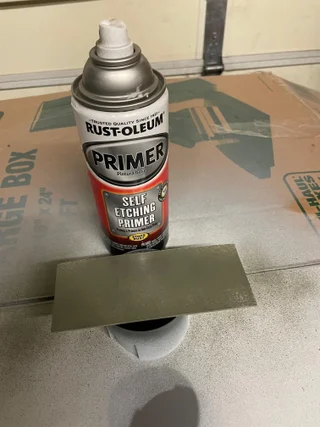 Rust Oleum primer spray with a test sample on metal surface