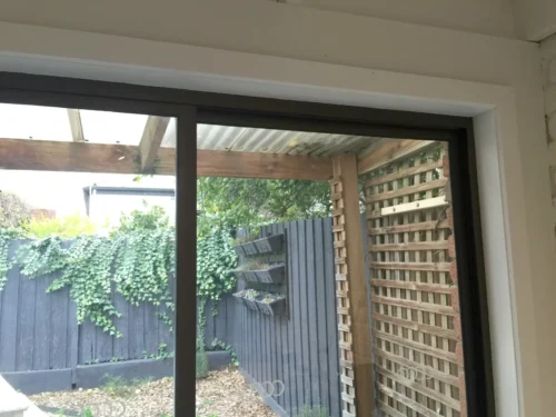 Sliding glass door overlooking a backyard garden