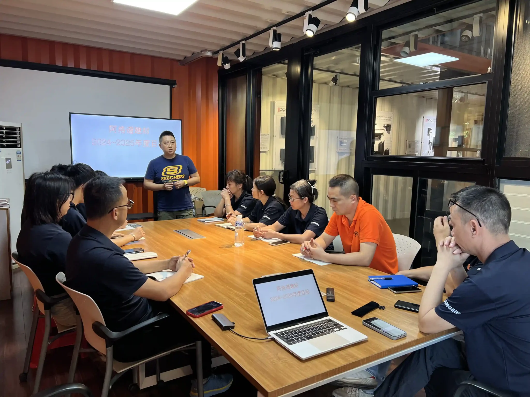 Team meeting in a conference room with laptops and presentations