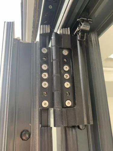 A close up view of the hinge mechanism on an aluminum bifold door