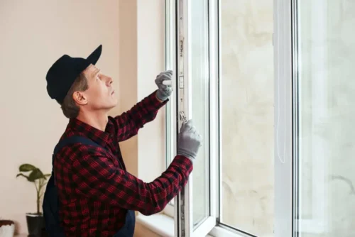 Hombre inspeccionando la alineación de la ventana durante el proceso de instalación