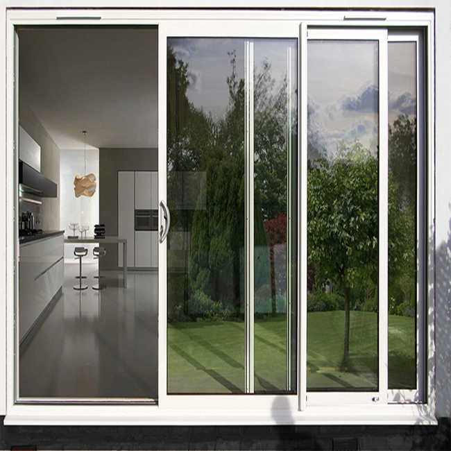 Porte coulissante en aluminium blanc ouvrant sur un jardin et une cuisine