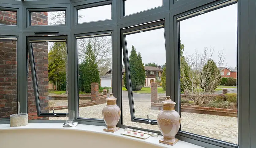 A curved bow window with multiple panes open offering views