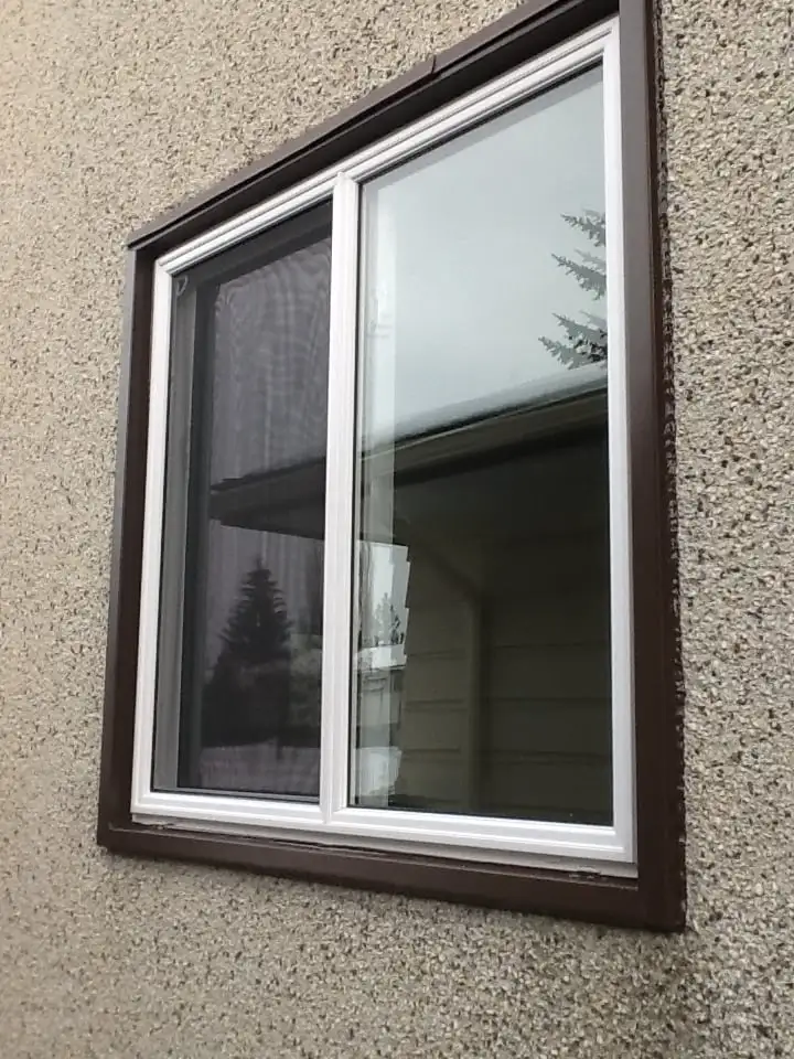 A window with a white frame partway open showing trees