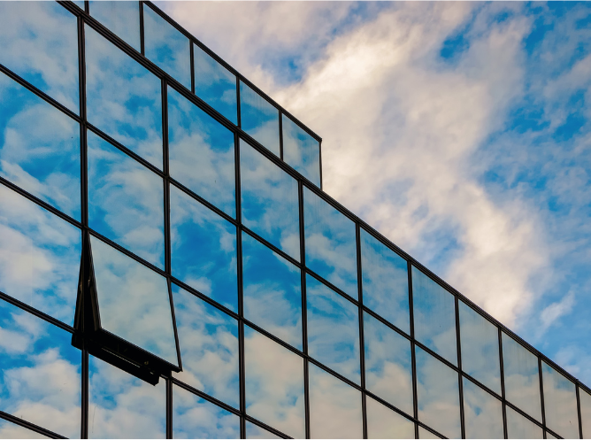 Buildings glass curtain wall reflecting the blue sky and clouds