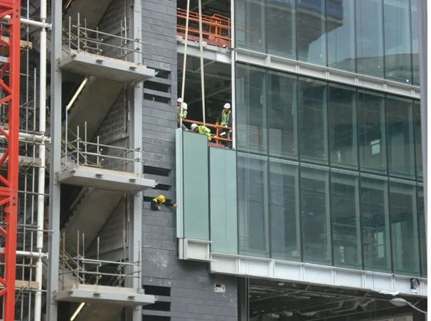 Five workers are installing modular curtain walls